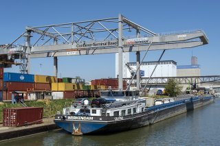 Un porte-conteneurs dans le port de Bâle. En 2024, si on peut s'attendre à une reprise de la demande mondiale et des exportations, la consommation pourrait perdre de sa vigueur, estime le Seco. (archives)